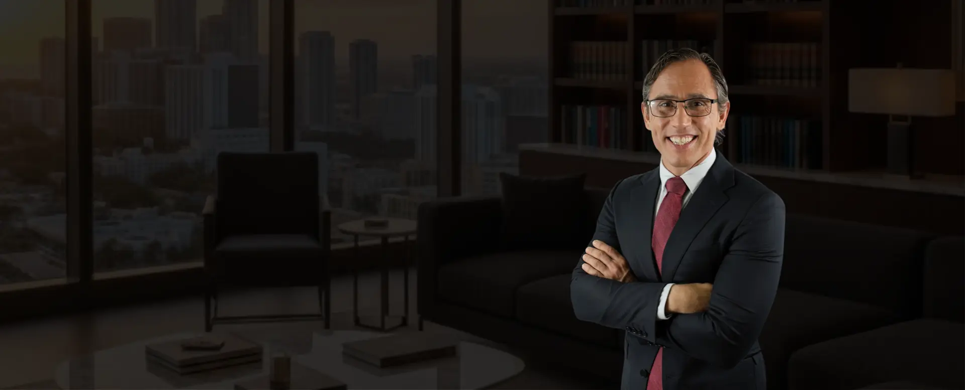 Abogado de Recoba Law Office en su oficina con vista al skyline de Miami